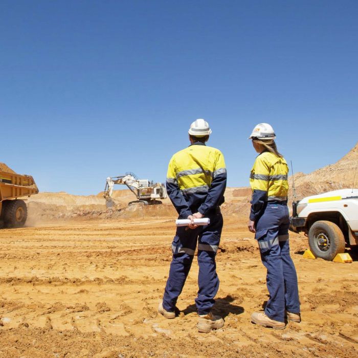 Field crew reviewing plans at an open-pit mine site
